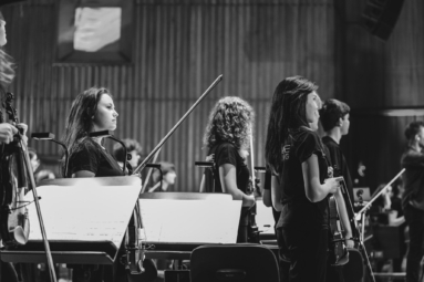 zdjęcie młodych muzyków Orchestry4Young zwróconych w stronę publicznosci