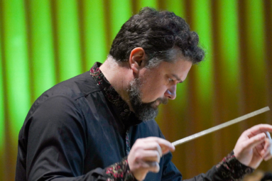 zdjęcie dyrygenta w czarnych, gęstych włosach i siwiejącym zaroście