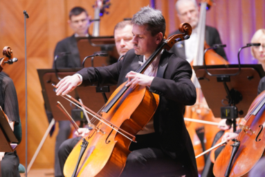 zdjęcie muzyka grającego na wiolonczeli z zamknietymi oczami