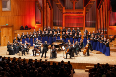zdjęcie orkiestry kameralnej i chóru kameralnego w granatowych spódnicach na estradzie FP