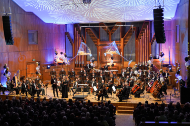 zdjęcie orkiestry symfonicznej na estradzie wystrojonej balonami