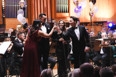 zdjęcie solistów wznoszących toast na estradzie FP