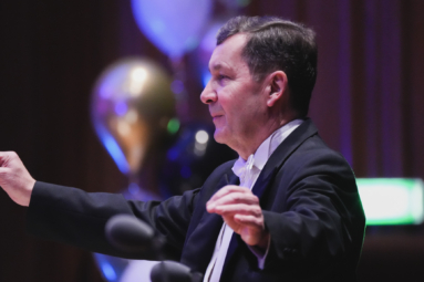 Zdjęcie dyrygenta z uniesionymi rękoma