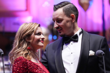 zdjęcie śpiewaków kobiety i mężczyzny w wieczorowych strojach, spoglądających sobie w oczy