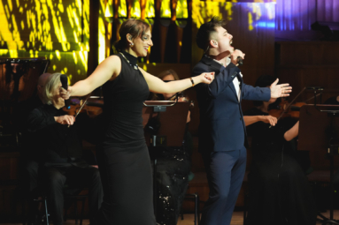 zdjęcie młodej kobiety i mężczyzny w eleganckich strojach, śpiewających do mikrofonów