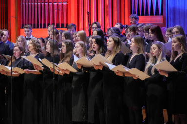 zdjęcie chórzystów śpiewających z białych teczek