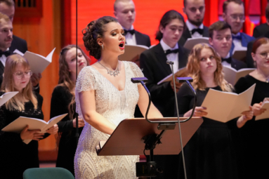 zdjęcie śpiewaczki w białej, świecącej sukience