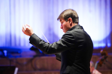 zdjęcie dyrygenta z uniesionymi rękami