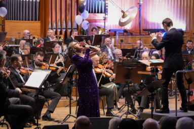 zdjęcie wokalistki w cekinowej sukience, śpiewającej do mikrofonu i odchylającej się do tyłu