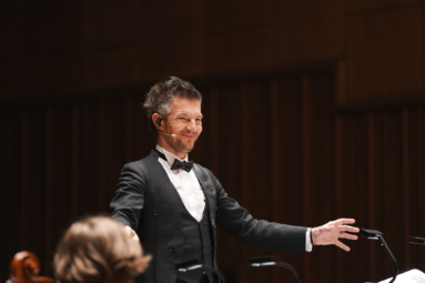 zdjęcie uśmiechniętego dyrygenta w smokingu i muszce