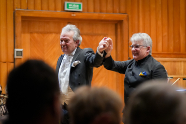 zdjęcie dwóch siwych mężczyzn - skrzypka i dyrygenta, kłaniających się publiczności