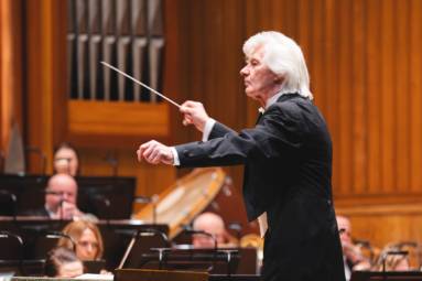 zdjęcie siwego dyrygenta z batutą w ręku