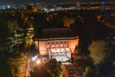 oświetlony gmach filharmonii pomorskiej widziany z lotu ptaka, podczas wieczornego koncertu plenerowego