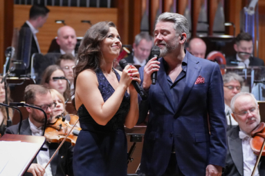 mężczyzna i kobieta śpiewający razem w duecie i uśmiechający się do siebie