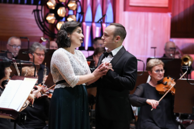 zdjęcie kobiety i mężczyzny w objęciach śpiewających do siebie, spoglądając sobie w oczy