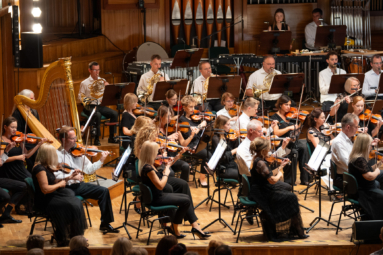 zdjęcie muzyków orkiestry symfonicznej na estradzie filharmonii podczas koncertu
