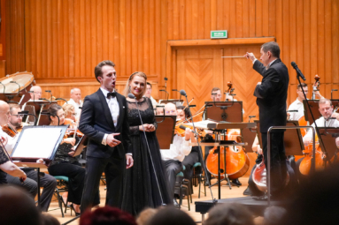 śpiewacy, dyrygent i orkiestra na estradzie FP w eleganckich strojach