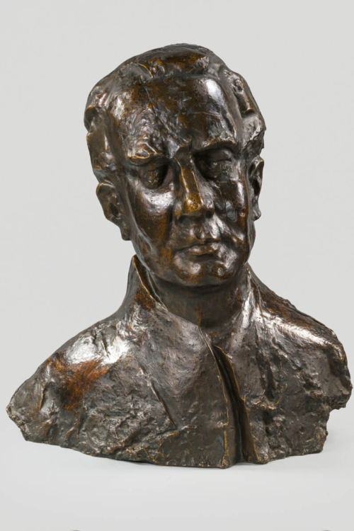 Popiersie wykonane z brązu przedstawia głowę Artura Malawskiego z realistycznymi rysami twarzy i detalami.