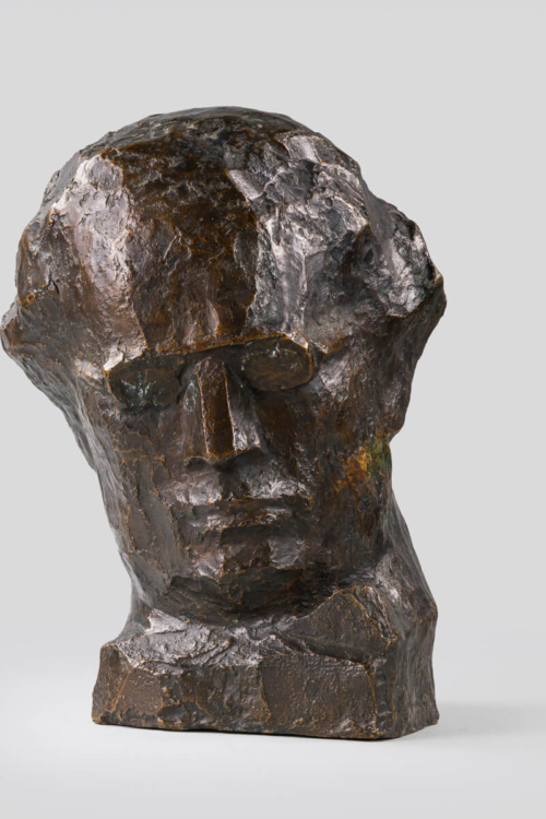 Popiersie wykonane z brązu przedstawia głowę Grzegorza Fitelberga z realistycznymi rysami twarzy i detalami.