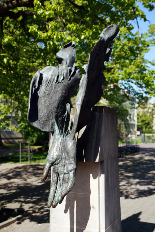 Alegoryczna rzeźba wykonana z brązu przedstawia dłoń objętą płomieniami.