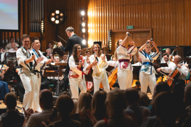 wokaliści w kolorowych strojach ABBY śpiewający i tańczący na estradzie